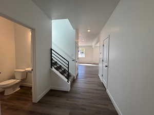 Hall with dark wood-type flooring and recessed lighting