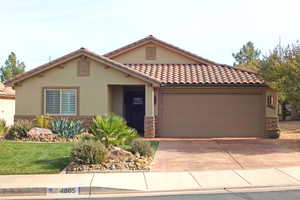 Mediterranean / spanish-style home featuring stone siding, concrete driveway, stucco siding, and a tiled roof