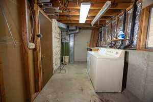 Unfinished basement featuring heating unit and independent washer and dryer