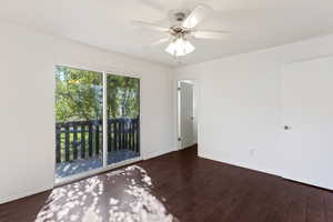 Spare room featuring dark wood-style floors and ceiling fan