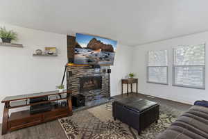 Living area with wood finished floors and a stone fireplace