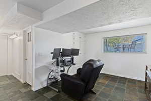 Home office featuring a textured ceiling and stone tile flooring
