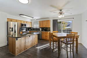 Kitchen with tasteful backsplash, healthy amount of natural light, dark wood-style floors, and stainless steel appliances