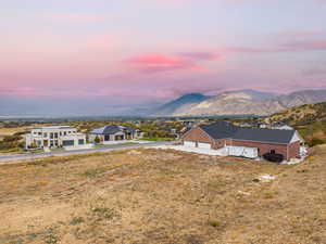 View of front facade featuring a mountain view, driveway, and a patio