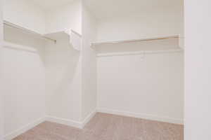 Walk in closet with light colored carpet