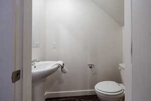 Bathroom featuring toilet and lofted ceiling