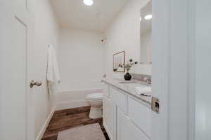 Bathroom featuring vanity, dark wood-type flooring, and bathing tub / shower combination