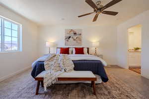Bedroom featuring carpet floors, connected bathroom, and a ceiling fan