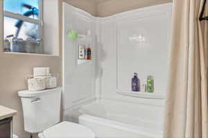 Bathroom featuring shower / tub combo with curtain and vanity