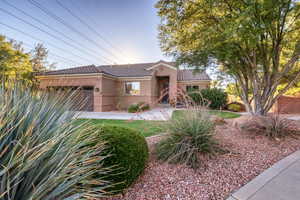 View of front of property featuring a tile roof, stucco siding, and a garage