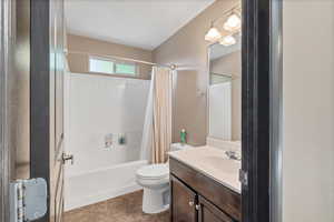 Bathroom featuring shower / bath combination with curtain, vanity, and tile patterned flooring