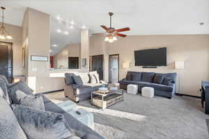 Living room featuring high vaulted ceiling, carpet, and a ceiling fan