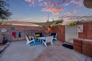 Patio terrace at dusk featuring a patio area and a fenced backyard