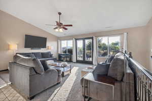 Living area with carpet floors, lofted ceiling, and a ceiling fan