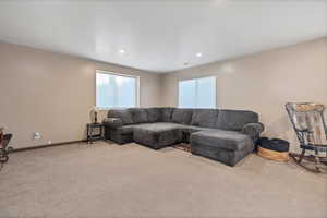 Carpeted living room with baseboards and recessed lighting