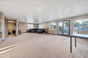 Living area featuring light colored carpet, recessed lighting, and french doors