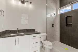 Bathroom with vanity, a marble finish shower, and light marble finish floors