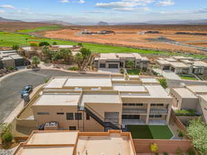 Aerial view of residential area featuring a mountainous background and a golf course