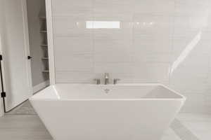 Bathroom with a freestanding tub and tile walls