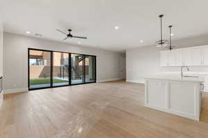 Unfurnished living room with recessed lighting, light wood-style floors, stairs, and ceiling fan