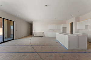 Kitchen featuring visible vents, white cabinets, and a kitchen island
