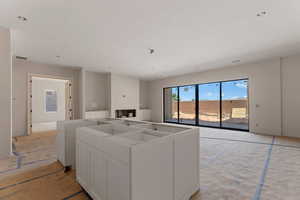 Kitchen with open floor plan, visible vents, a kitchen island, and white cabinets