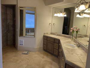 Primary Suite Full bath featuring double vanity, a stall shower, and heating unit