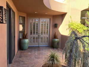Entrance to property featuring french doors, stucco siding, and a patio area