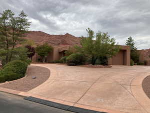 Southwest Style home featuring stucco siding, curved driveway, and a Red Rock mountain view
