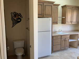 Bathroom and Kitchenette in Pool Room with light countertops, and brown cabinets