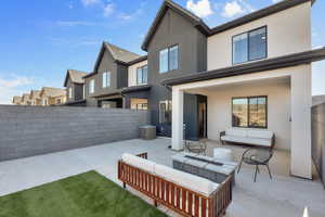 Rear view of house featuring a patio, stucco siding, an outdoor living space, and a fenced backyard