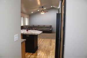 Living area featuring light wood-style flooring, lofted ceiling, a ceiling fan, and recessed lighting