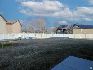 View of yard featuring a fenced backyard and a trampoline
