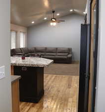 Kitchen with light wood-style flooring, open floor plan, vaulted ceiling, recessed lighting, and a ceiling fan