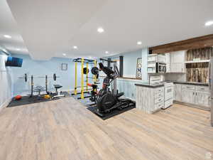 Exercise area with recessed lighting, baseboards, and light wood-type flooring