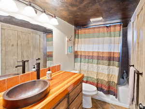 Bathroom featuring vanity, toilet, tile patterned floors, and shower / tub combo