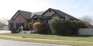 Single story home with a gate, concrete driveway, brick siding, an attached garage, and roof with shingles