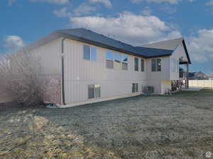 Rear view of property featuring a yard, fence, cooling unit, and a shingled roof