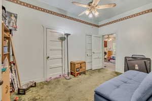 Living area with carpet flooring and a ceiling fan