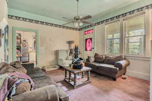 Living room featuring carpet and ceiling fan