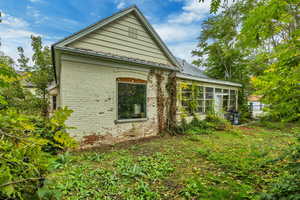 View of home's exterior featuring a sunroom and brick siding