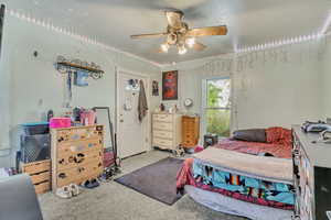 Carpeted bedroom with ceiling fan