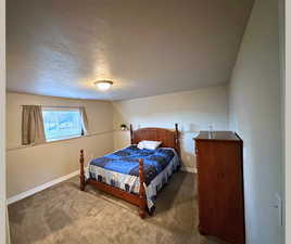 Bedroom with carpet floors and a textured ceiling