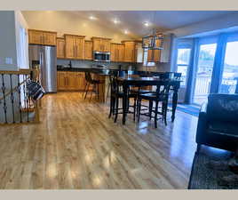 Dining room with light wood finished floors, recessed lighting, and high vaulted ceiling