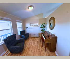 Living area featuring vaulted ceiling and light wood-style floors
