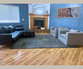 Living area featuring a decorative wall, a high end fireplace, and wood finished floors