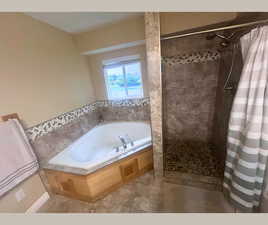 Bathroom featuring a stall shower, a whirlpool tub, and light tile patterned flooring