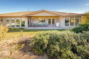 Back of house with stucco siding, a patio, a tile roof, and a yard