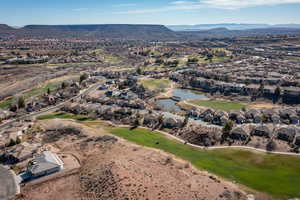 Aerial view of property and surrounding area with a water and mountain view, nearby suburban area, and a local golf course