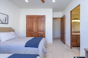 Bedroom with recessed lighting, light colored carpet, a closet, a ceiling fan, and connected bathroom